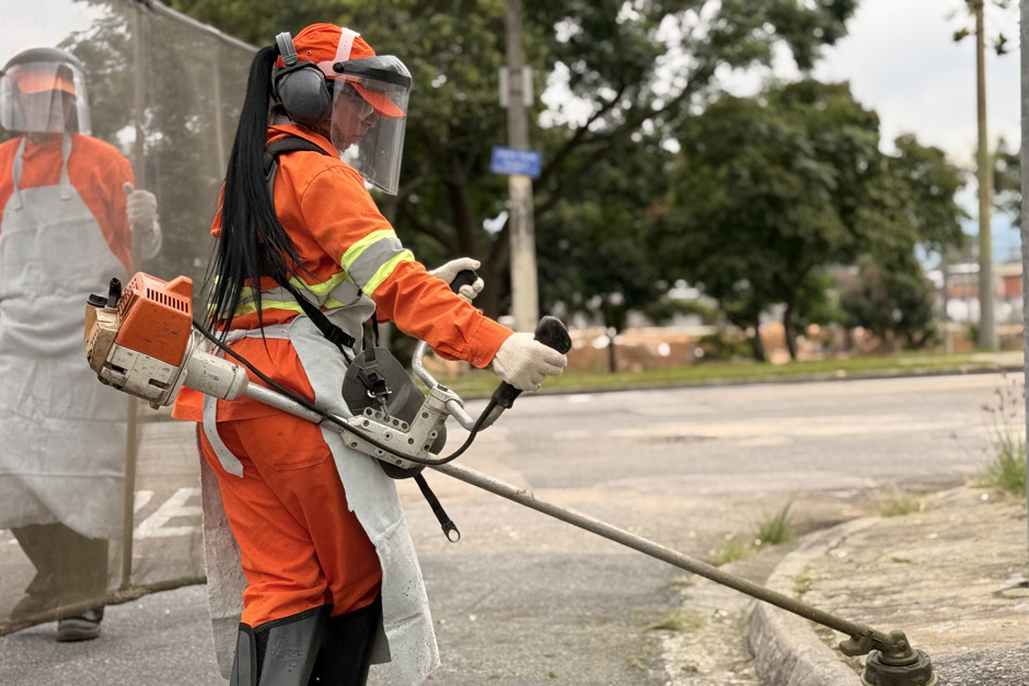 Trabalhadoras da Urbam realizam serviço de capina em guia de esquina de um bairro de São José