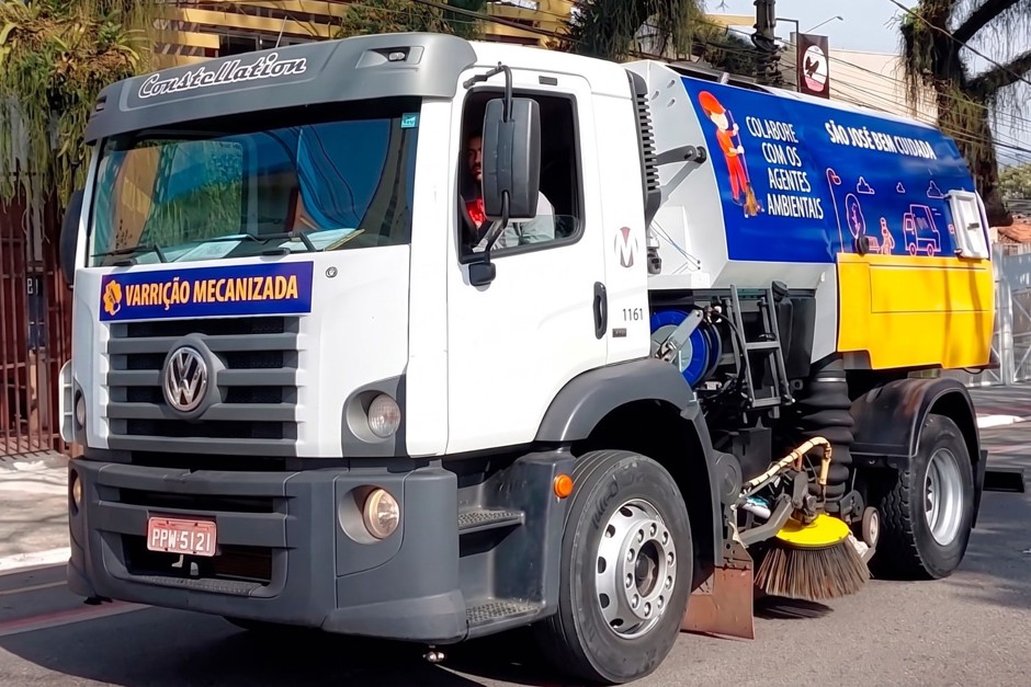 Caminhão da varredeira mecanizada trafega nas ruas de São José com adesivos que enfatizam a qualidade da limpeza pública da cidade