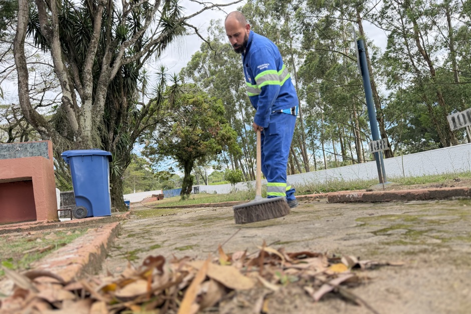 Funcionário da Urbam varre folhas e galhos do caminho no Cemitério Distrital de Eugênio de Melo